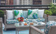 Outdoor seating area at The Whitby Hotel by Firmdale Hotels, featuring benches upholstered in Lost and Found Turchese and Carnival Verde performance weaves. A vibrant mix of pattern and colour creates an inviting alfresco setting for dining and lounging.